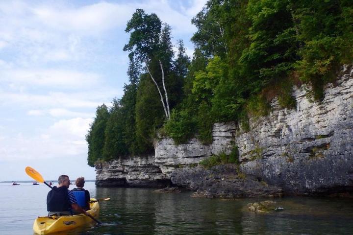 a man riding on the back of a boat in the water