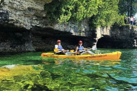 a group of people riding on the back of a boat in the water