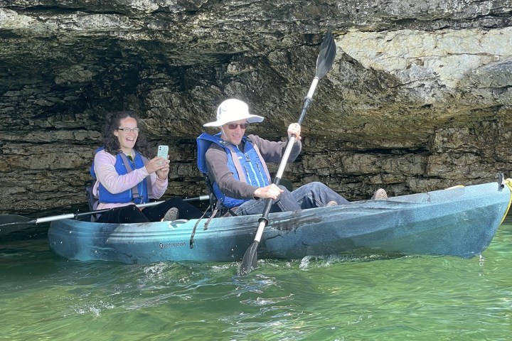 a group of people riding on the back of a boat in the water