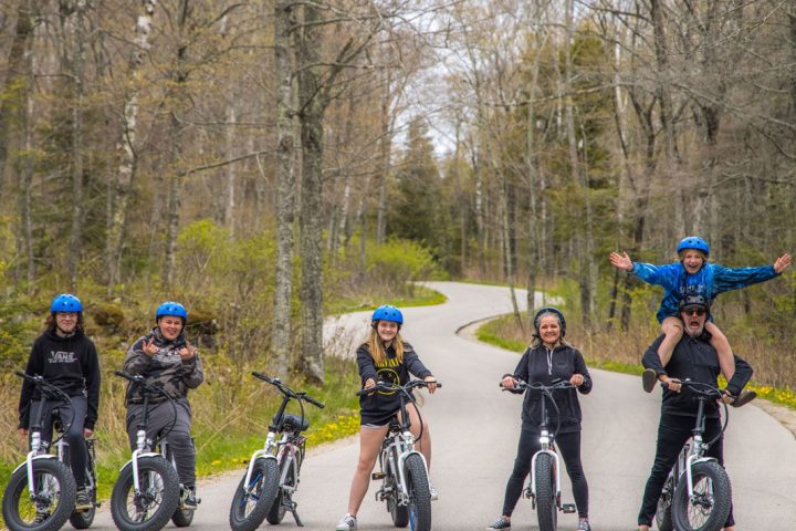 a group of people riding on the back of a bicycle